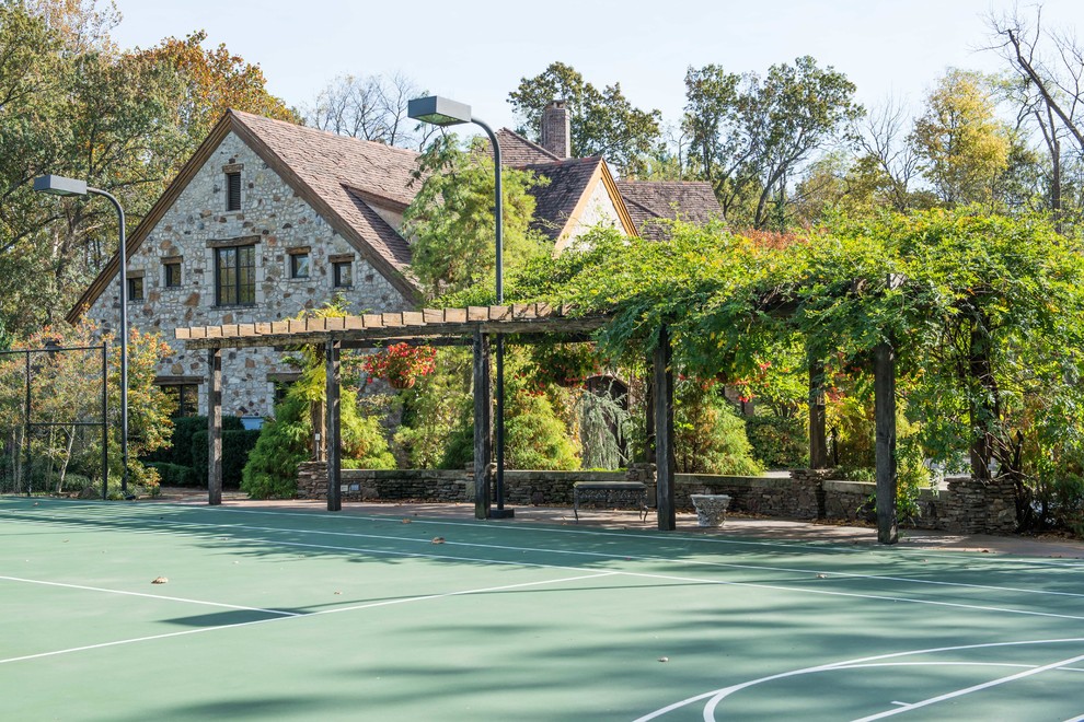 Halbschattiger Rustikaler Garten hinter dem Haus mit Spielgerät und Natursteinplatten in St. Louis