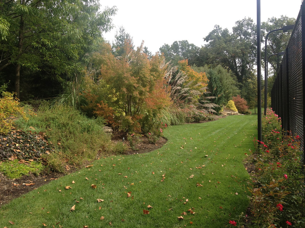 Halbschattiger Uriger Garten hinter dem Haus mit Natursteinplatten in St. Louis