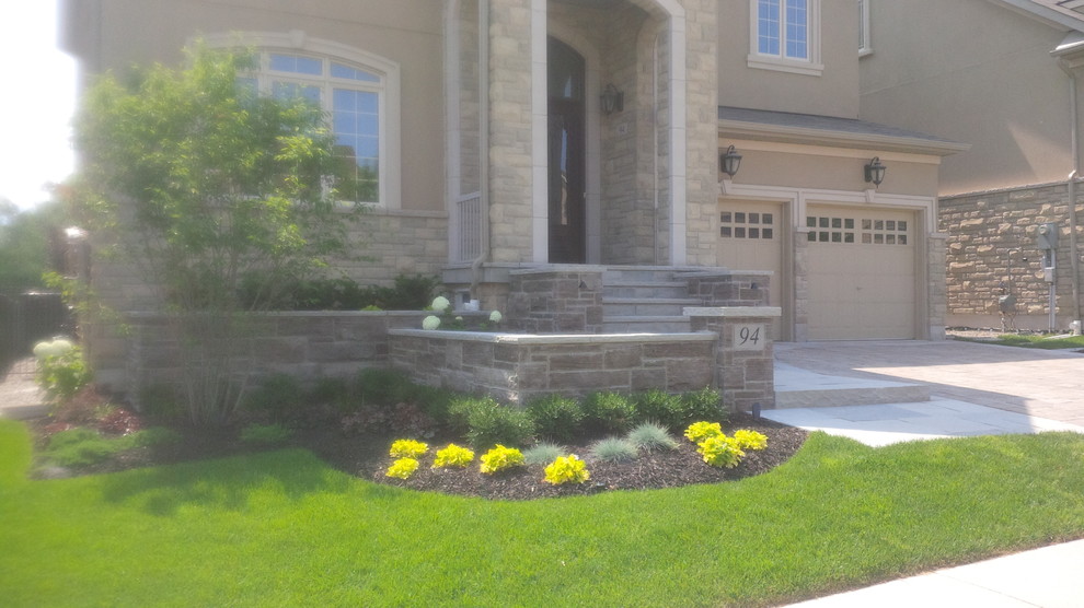 Photo of a traditional shade front yard stone landscaping in Toronto.