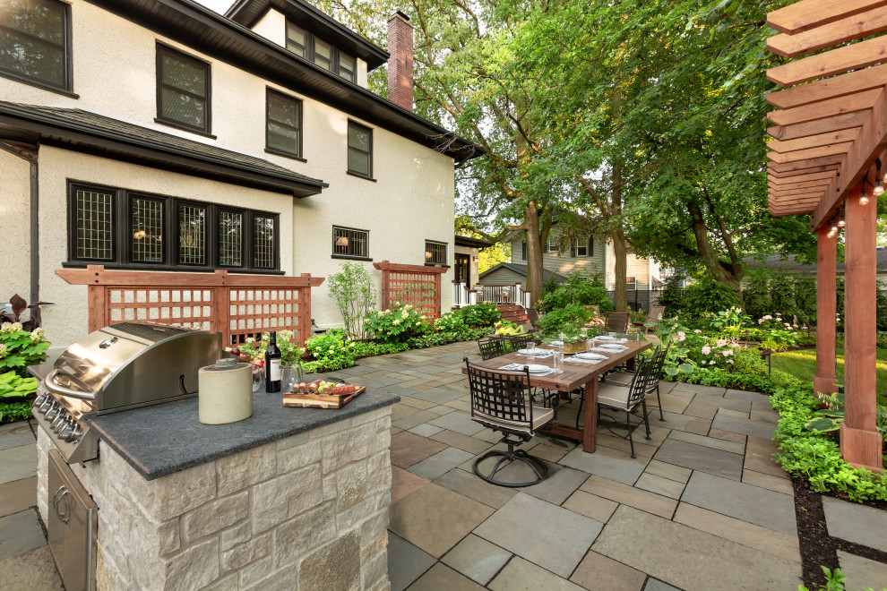 Patio - large traditional backyard stone patio idea in Chicago with a fire pit