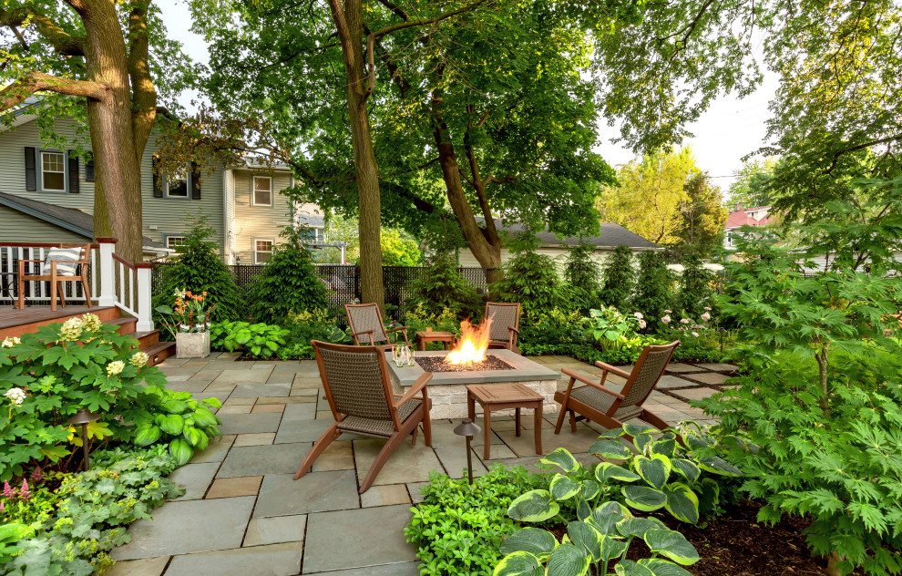 Großer, Schattiger Klassischer Garten im Sommer, hinter dem Haus mit Feuerstelle und Natursteinplatten in Chicago