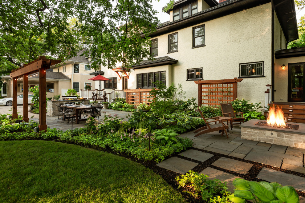 シカゴにある高級な広い、夏のトラディショナルスタイルのおしゃれな裏庭 (ファイヤーピット、日陰、天然石敷き) の写真