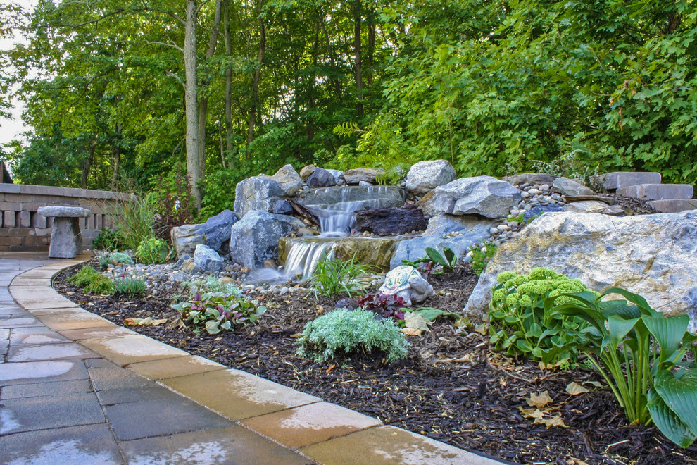 This is an example of a small modern backyard water fountain landscape in New York.