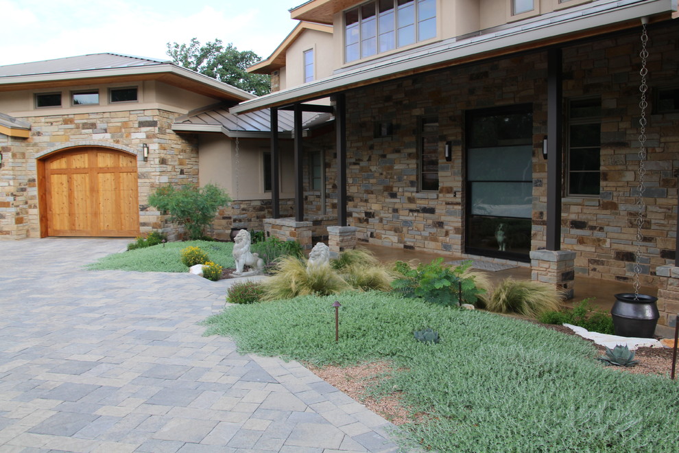 This is an example of a large contemporary drought-tolerant and full sun front yard brick landscaping in Austin.