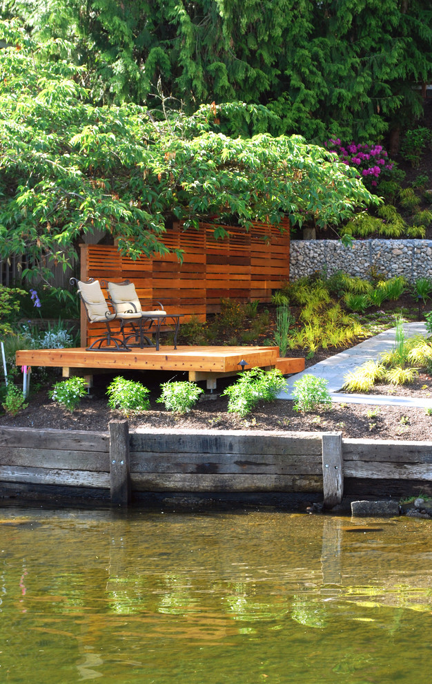 Идея дизайна: маленький засухоустойчивый сад на боковом дворе в стиле модернизм с подпорной стенкой, полуденной тенью и покрытием из каменной брусчатки для на участке и в саду