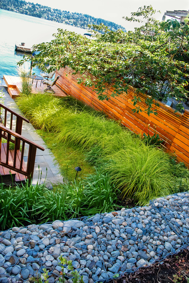 Kleiner, Halbschattiger Maritimer Garten im Sommer, neben dem Haus mit Wasserspiel und Natursteinplatten in Seattle