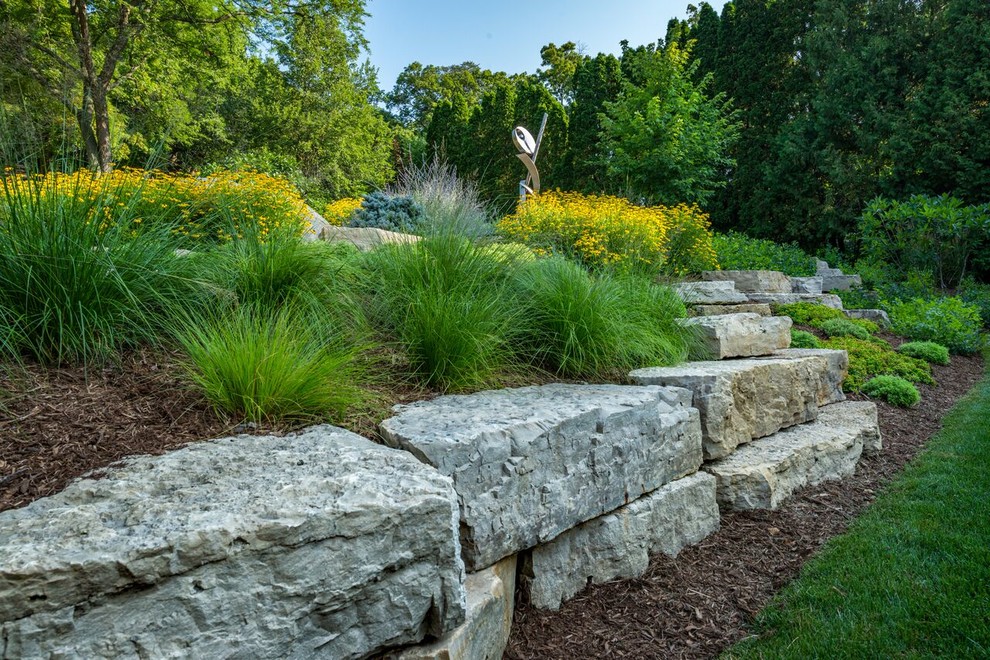 Ispirazione per un grande giardino chic esposto in pieno sole davanti casa con un muro di contenimento e pacciame