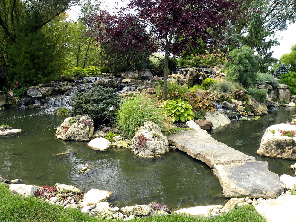 На фото: огромный летний садовый фонтан на заднем дворе в классическом стиле с полуденной тенью и покрытием из каменной брусчатки с