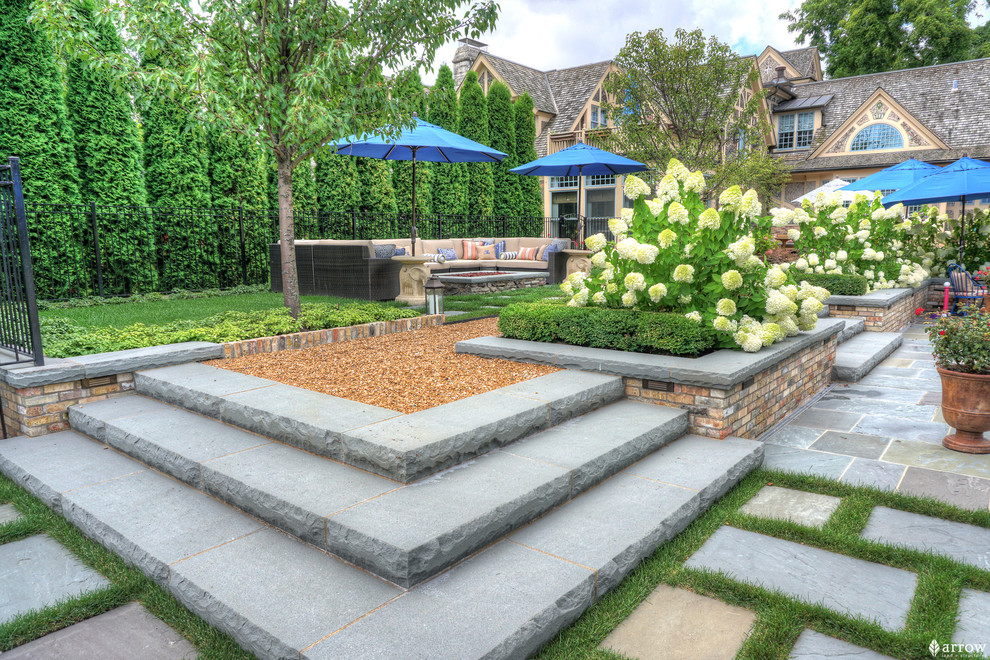 Design ideas for a medium sized traditional back formal full sun garden for summer in Chicago with a garden path and natural stone paving.