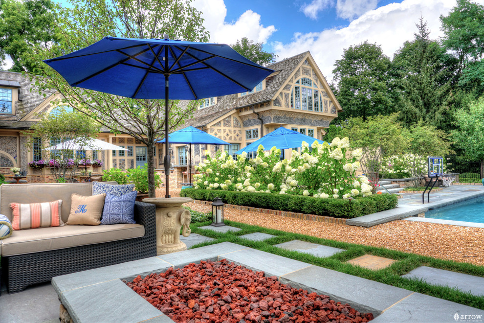 Пример оригинального дизайна: солнечный, летний регулярный сад среднего размера на заднем дворе в классическом стиле с местом для костра, хорошей освещенностью и покрытием из каменной брусчатки