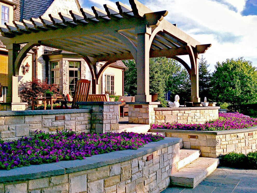 Photo of a classic back garden in Chicago with a retaining wall and natural stone paving.