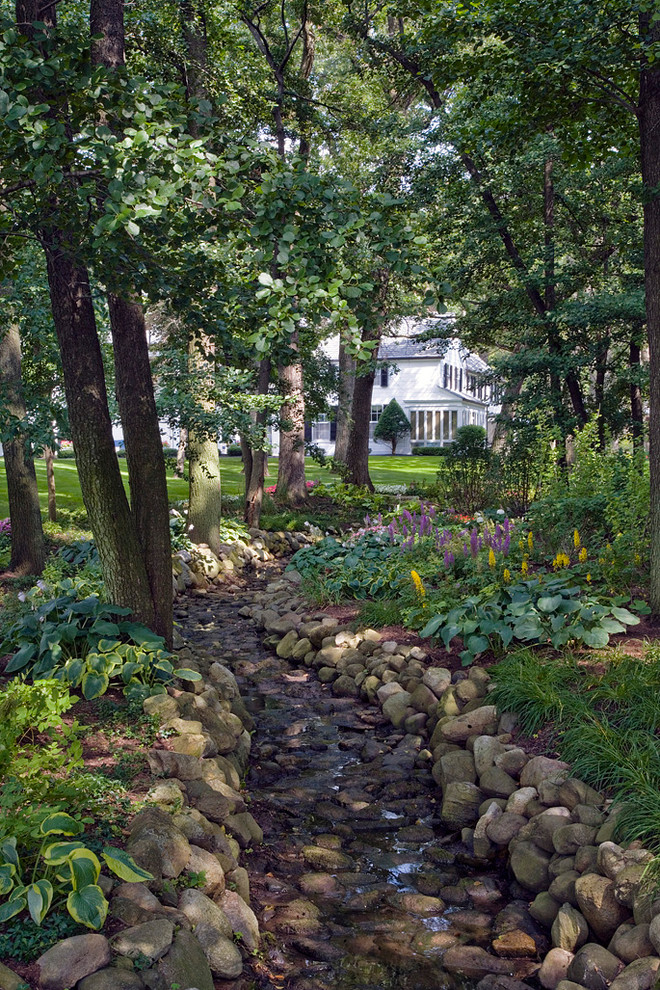 Inspiration for a traditional back garden in Chicago with a water feature and decorative stones.