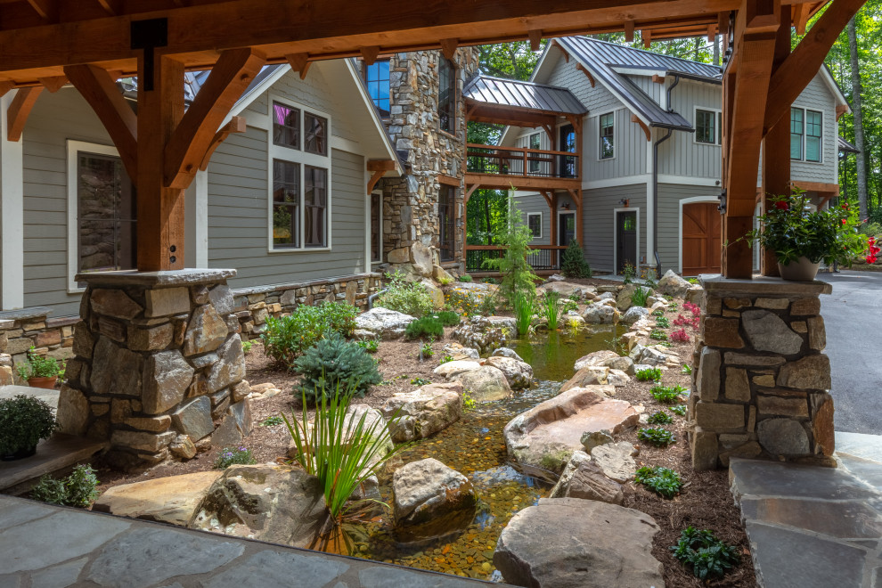 Inspiration for a huge craftsman partial sun front yard river rock landscaping in Other.