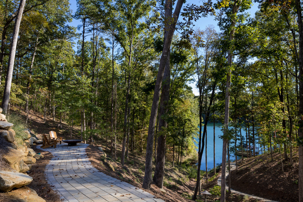 Photo of a large rustic back partial sun garden in Other with concrete paving and a fire feature.