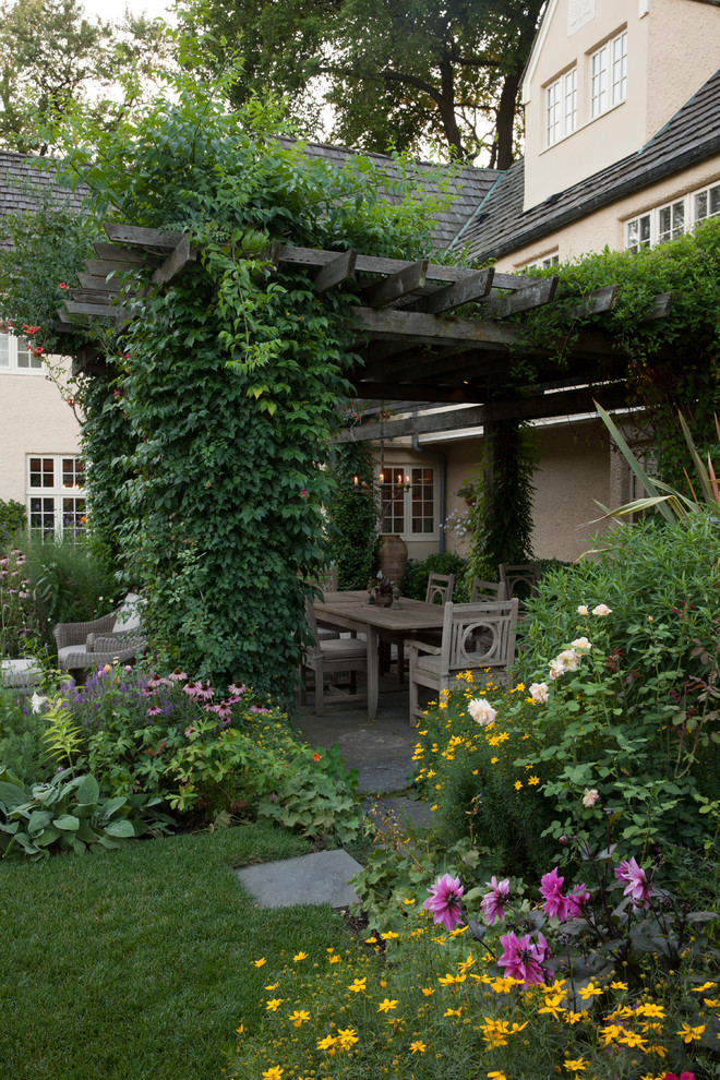Idée de décoration pour un grand jardin avec pergola arrière tradition avec des pavés en pierre naturelle.