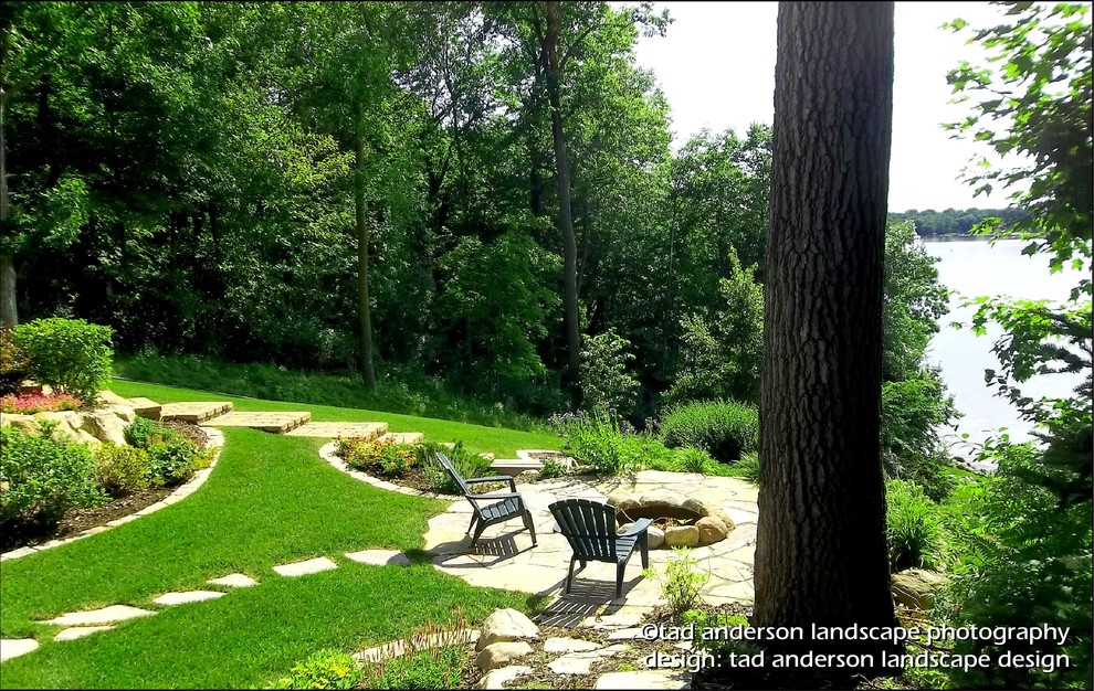 Diseño de jardín de estilo americano en verano en patio trasero con brasero, exposición parcial al sol y adoquines de piedra natural