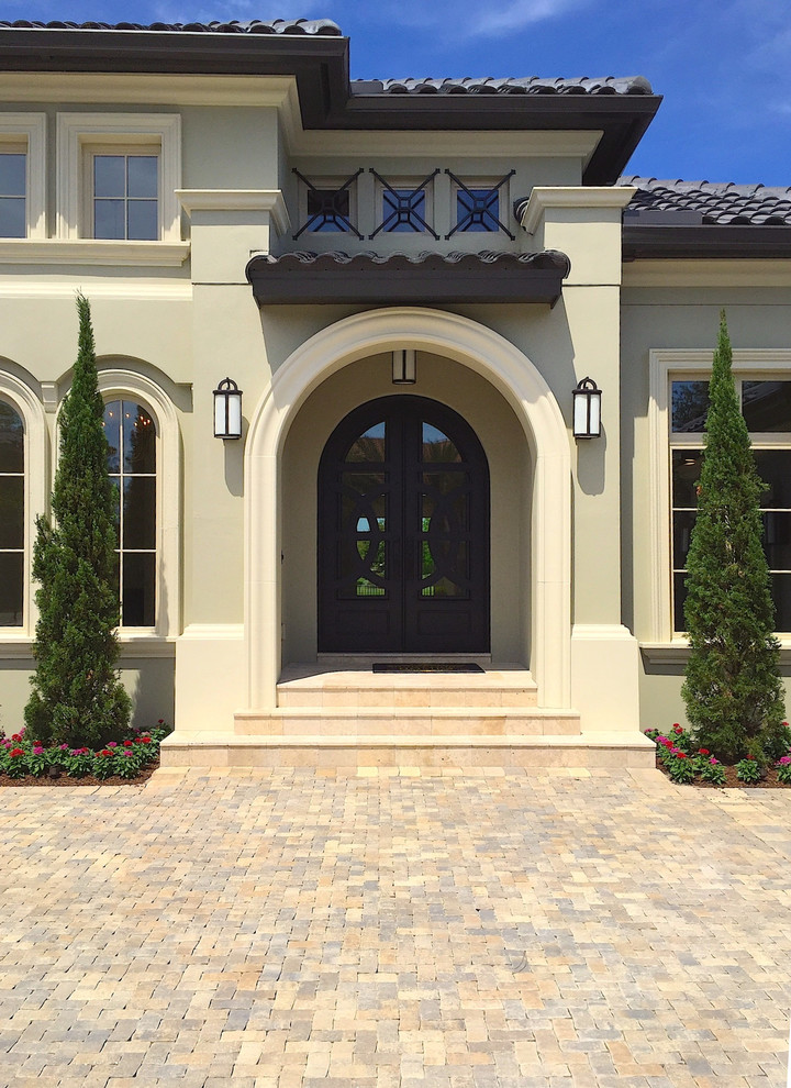 Inspiration for a large traditional front driveway partial sun garden in Orlando with natural stone paving.