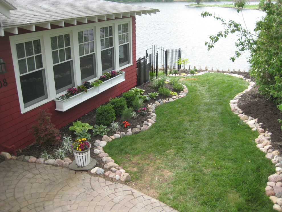 This is an example of a mid-sized traditional partial sun side yard mulch formal garden in Kansas City.