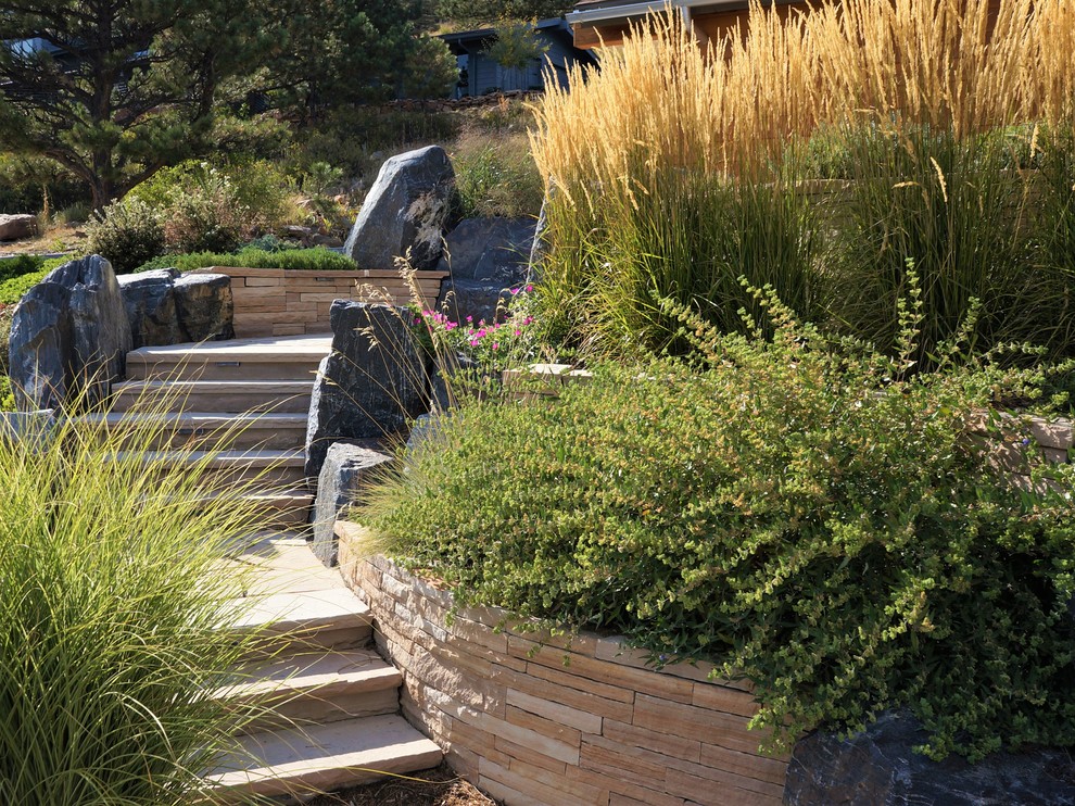 Идея дизайна: летний регулярный сад среднего размера на склоне в стиле неоклассика (современная классика) с подпорной стенкой, полуденной тенью и покрытием из каменной брусчатки