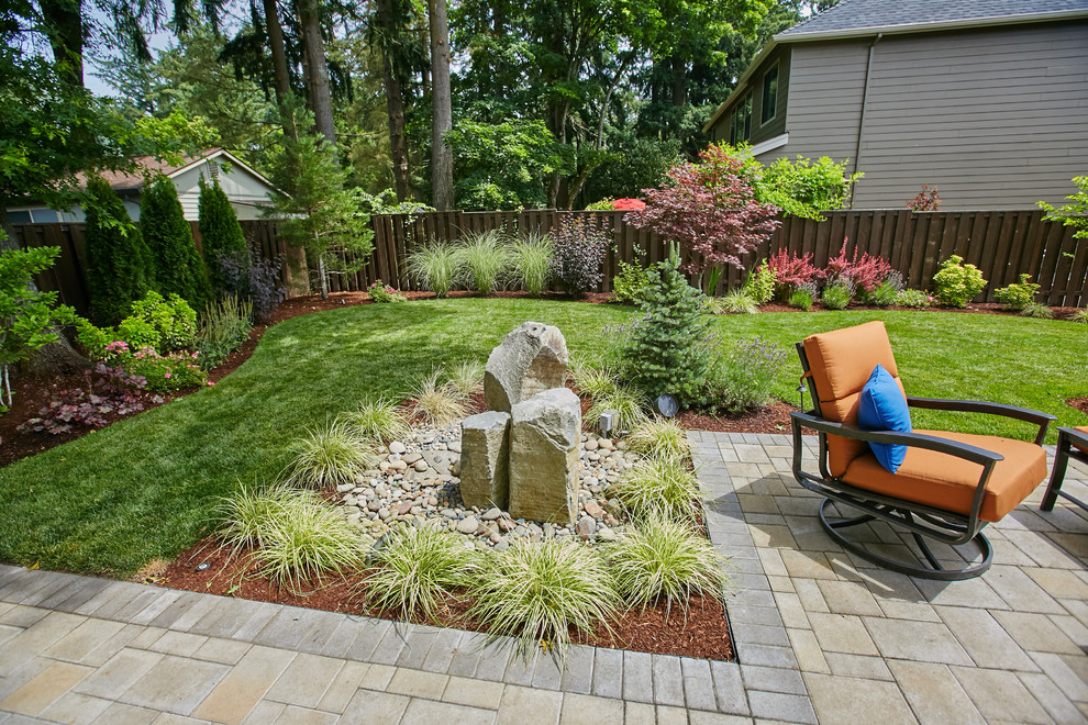 Diseño de jardín minimalista pequeño en patio trasero con fuente y adoquines de hormigón