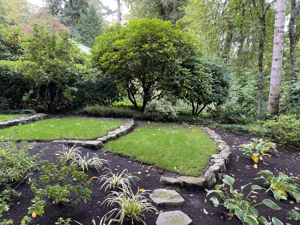 Immagine di un giardino classico in ombra di medie dimensioni con un pendio, una collina o una riva e pavimentazioni in cemento