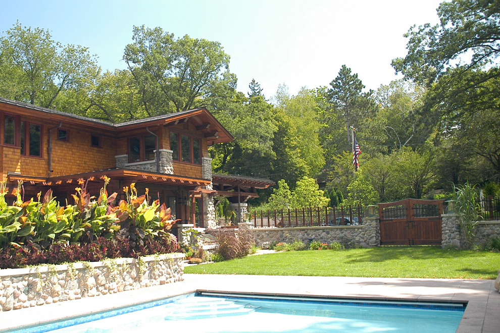 Diseño de jardín de estilo americano grande en patio lateral con muro de contención, exposición total al sol y adoquines de hormigón