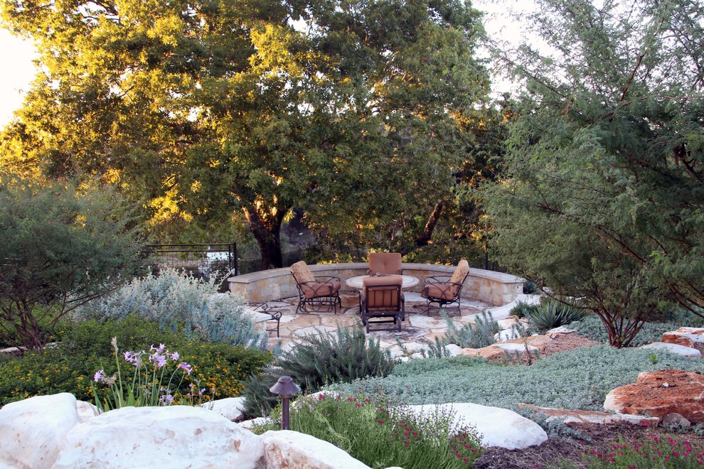 Großer Mediterraner Garten hinter dem Haus, im Sommer mit direkter Sonneneinstrahlung und Natursteinplatten in Austin