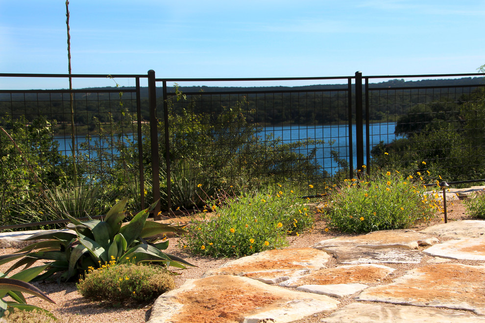 Imagen de jardín de secano mediterráneo grande en verano en patio trasero con exposición total al sol y adoquines de piedra natural