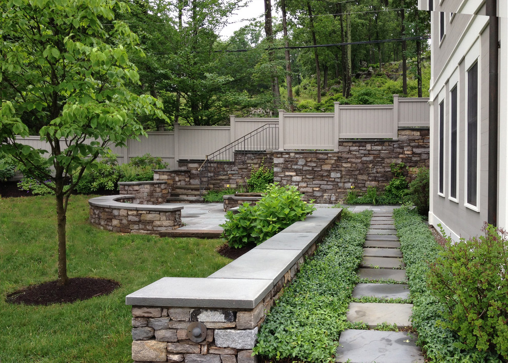 This is an example of a large contemporary full sun backyard concrete paver garden path in New York for fall.