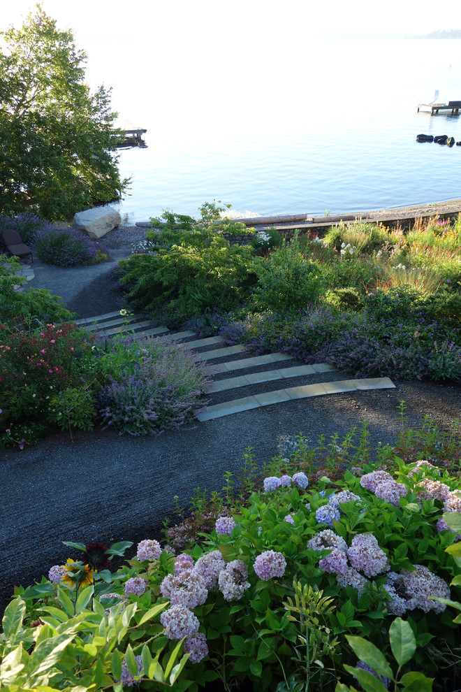На фото: большой солнечный, весенний регулярный сад на заднем дворе в классическом стиле с хорошей освещенностью и покрытием из гравия с