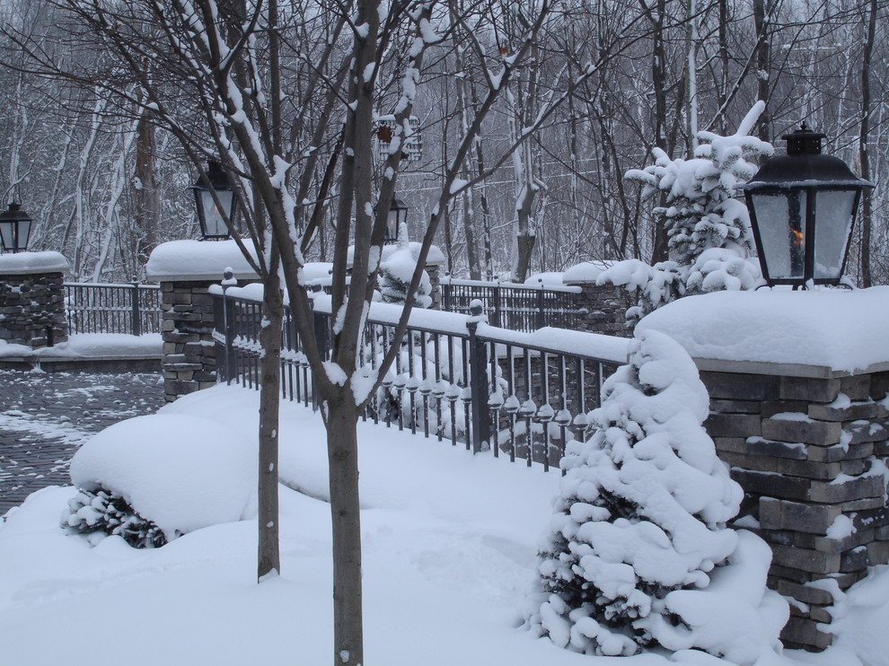 Großer, Halbschattiger Klassischer Garten im Winter mit Natursteinplatten in Grand Rapids