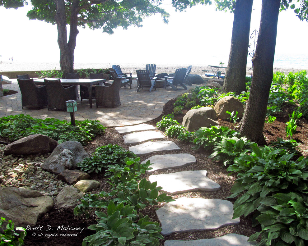Esempio di un giardino xeriscape stile marino esposto a mezz'ombra di medie dimensioni e dietro casa in estate con un ingresso o sentiero e pavimentazioni in pietra naturale
