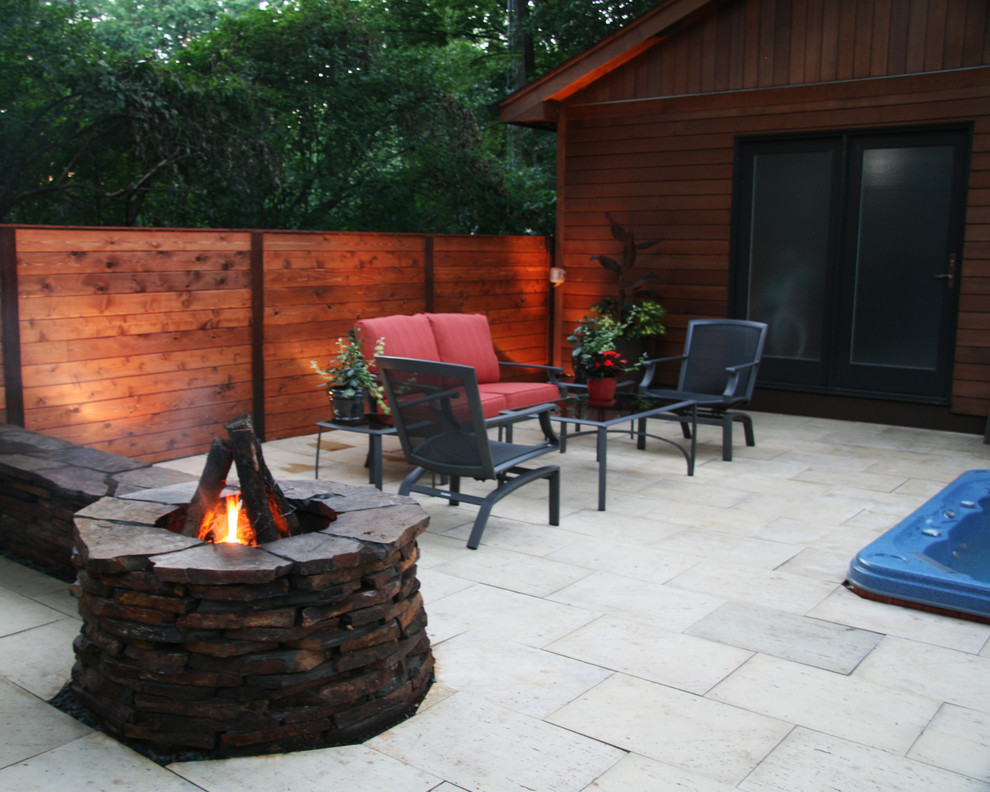 Modelo de patio rústico de tamaño medio en patio con brasero y adoquines de piedra natural
