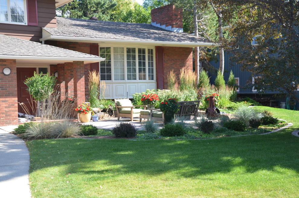 This is an example of a mid-sized traditional partial sun front yard concrete paver garden path in Calgary for summer.