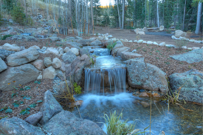 Cette photo montre un grand jardin arrière montagne l'été avec un bassin, une exposition ensoleillée et des pavés en pierre naturelle.