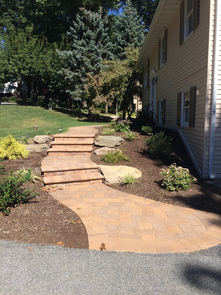 This is an example of a mid-sized traditional full sun side yard stone landscaping in Other.