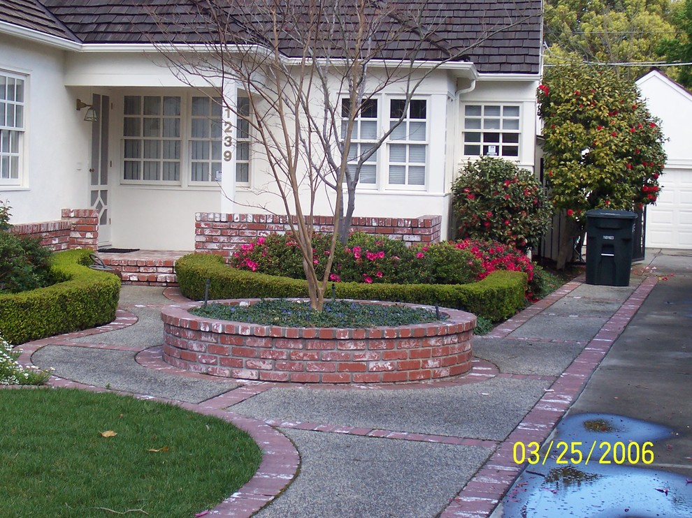 This is an example of a mid-sized traditional full sun front yard brick landscaping in Sacramento.