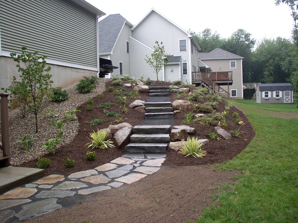This is an example of a mid-sized shade hillside stone landscaping in New York.