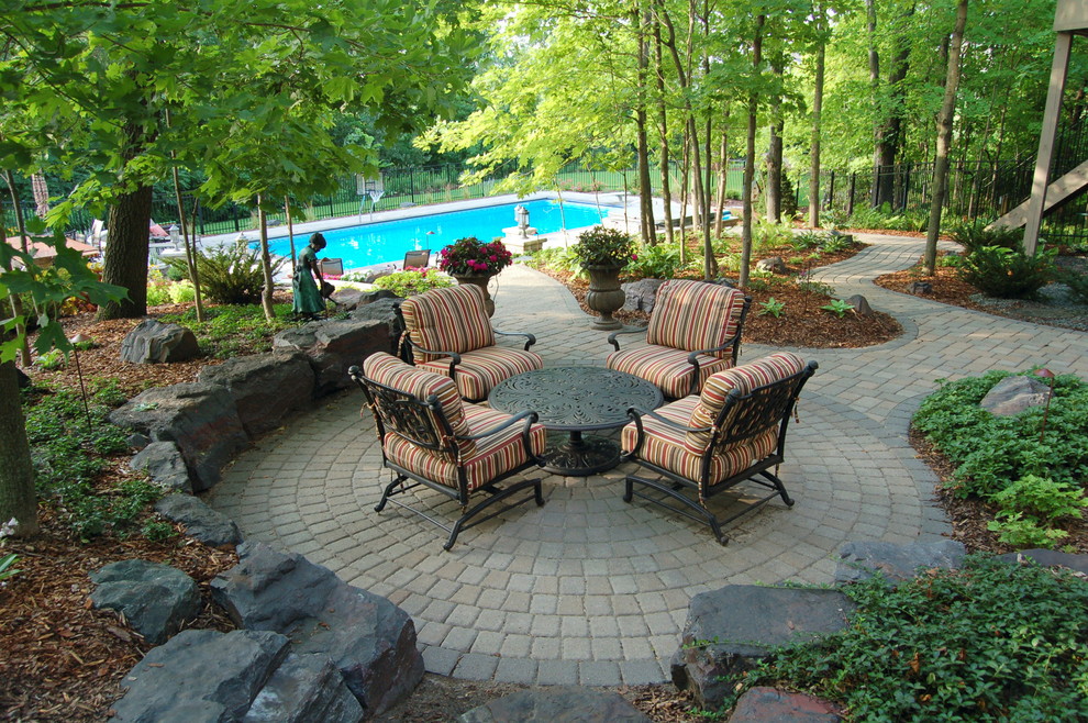 Expansive classic back fully shaded garden in Minneapolis with concrete paving.