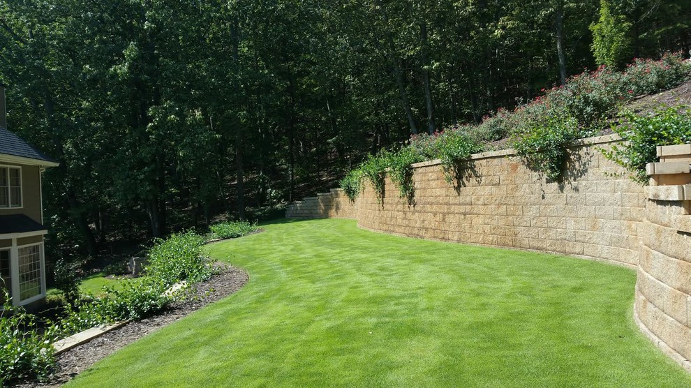 Photo of a mid-sized traditional shade backyard stone retaining wall landscape in Atlanta.