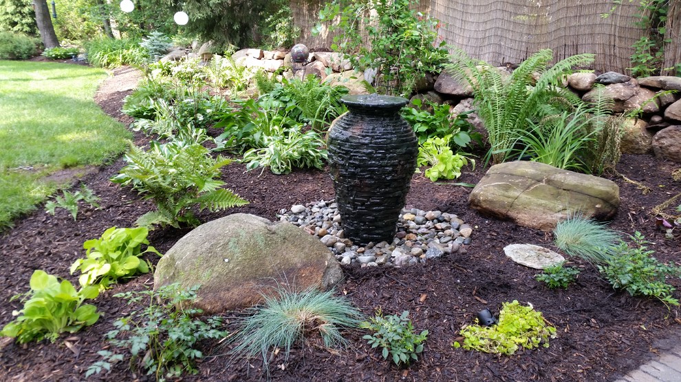 Ispirazione per un piccolo giardino formale minimalista esposto in pieno sole dietro casa con fontane e pacciame
