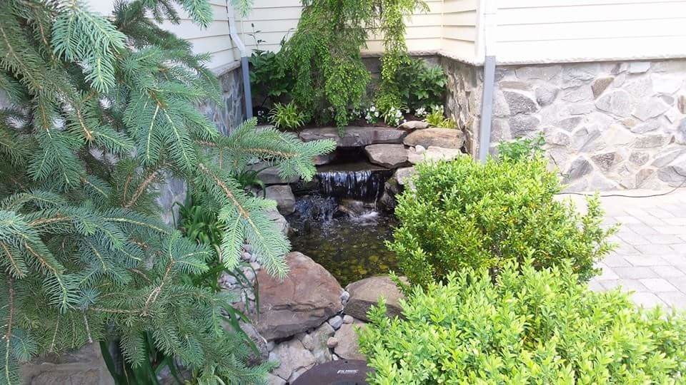 Small traditional back garden in New York with a water feature and brick paving.