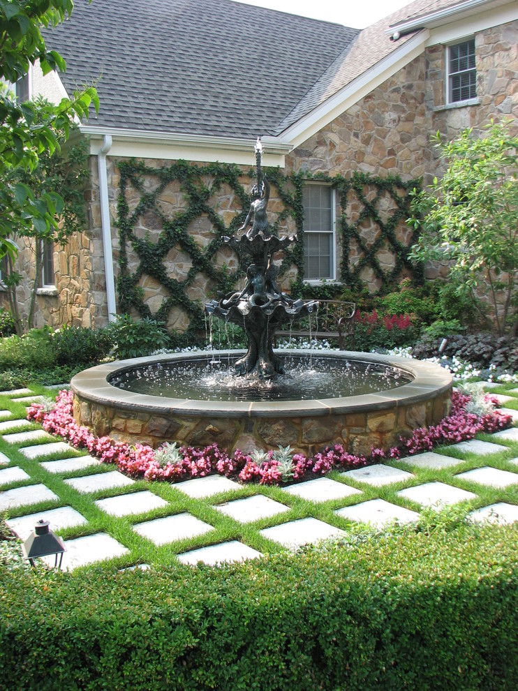 На фото: солнечный садовый фонтан в классическом стиле с хорошей освещенностью и мощением тротуарной плиткой с