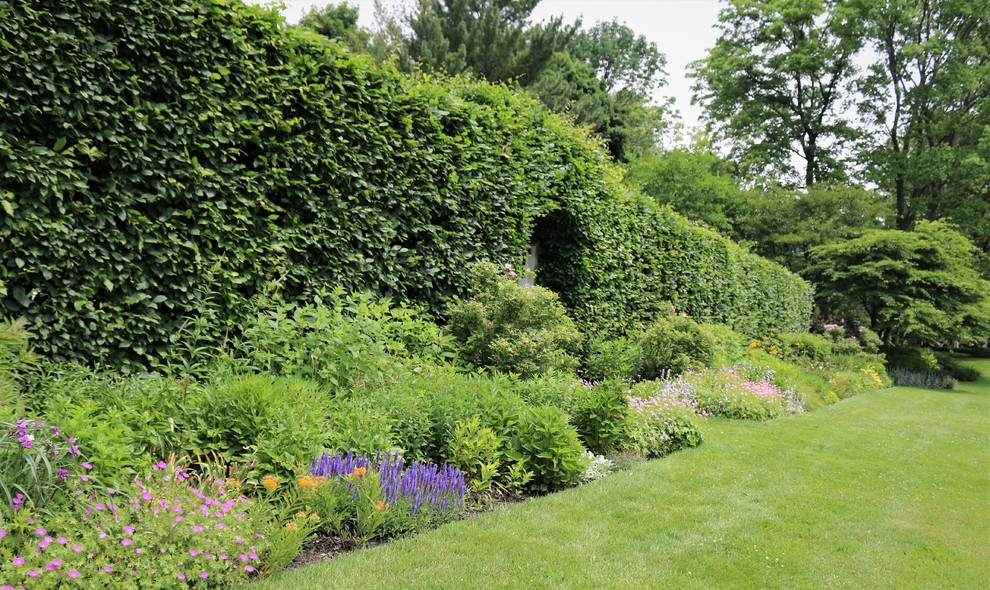 Idée de décoration pour un grand jardin arrière tradition l'été avec une exposition ensoleillée.