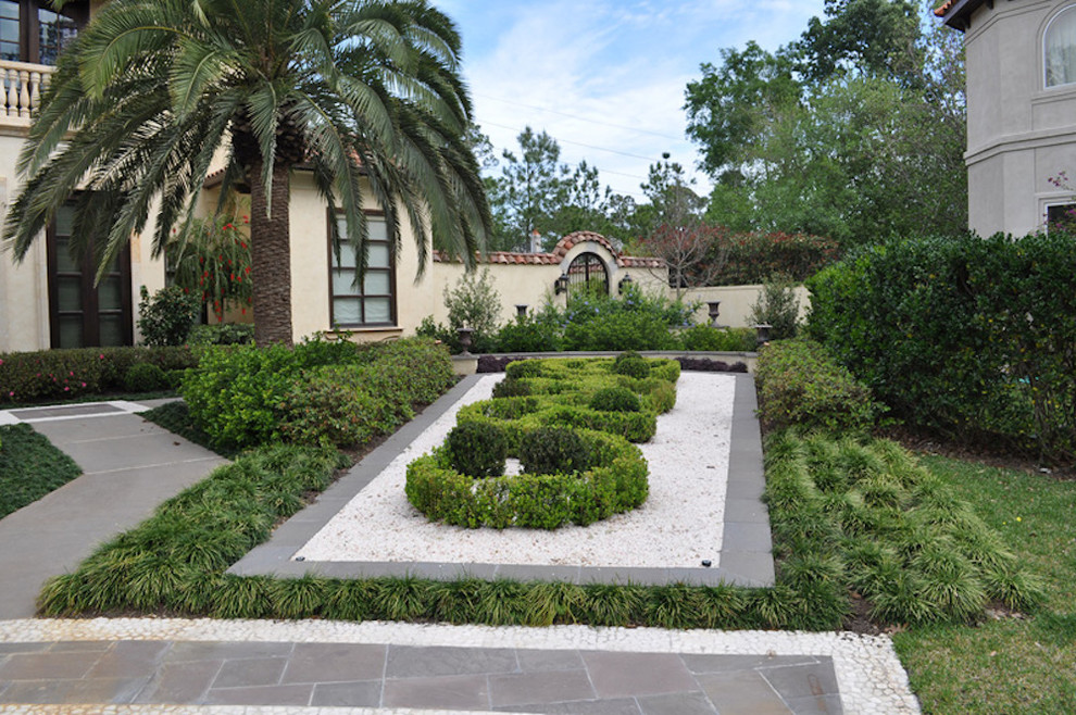 Cette image montre un grand aménagement d'entrée ou allée de jardin arrière méditerranéen avec une exposition ensoleillée et des pavés en béton.