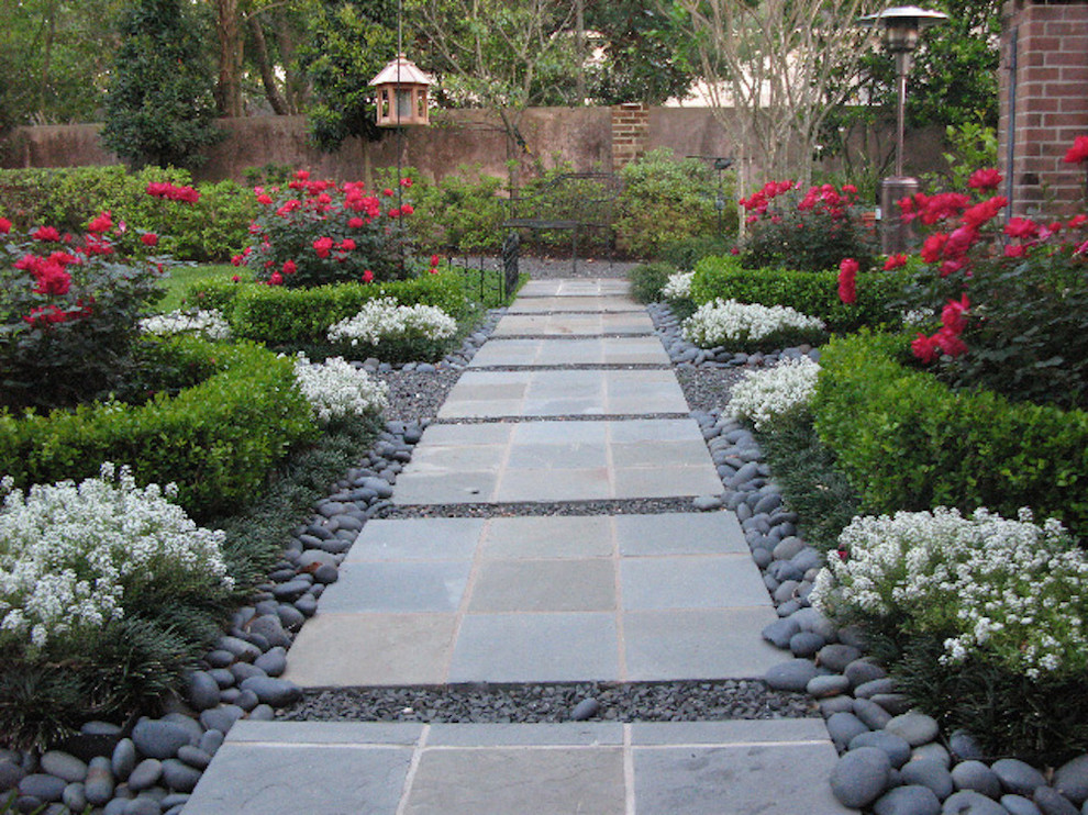 Immagine di un giardino formale tradizionale esposto in pieno sole nel cortile laterale e di medie dimensioni con un ingresso o sentiero e pavimentazioni in cemento