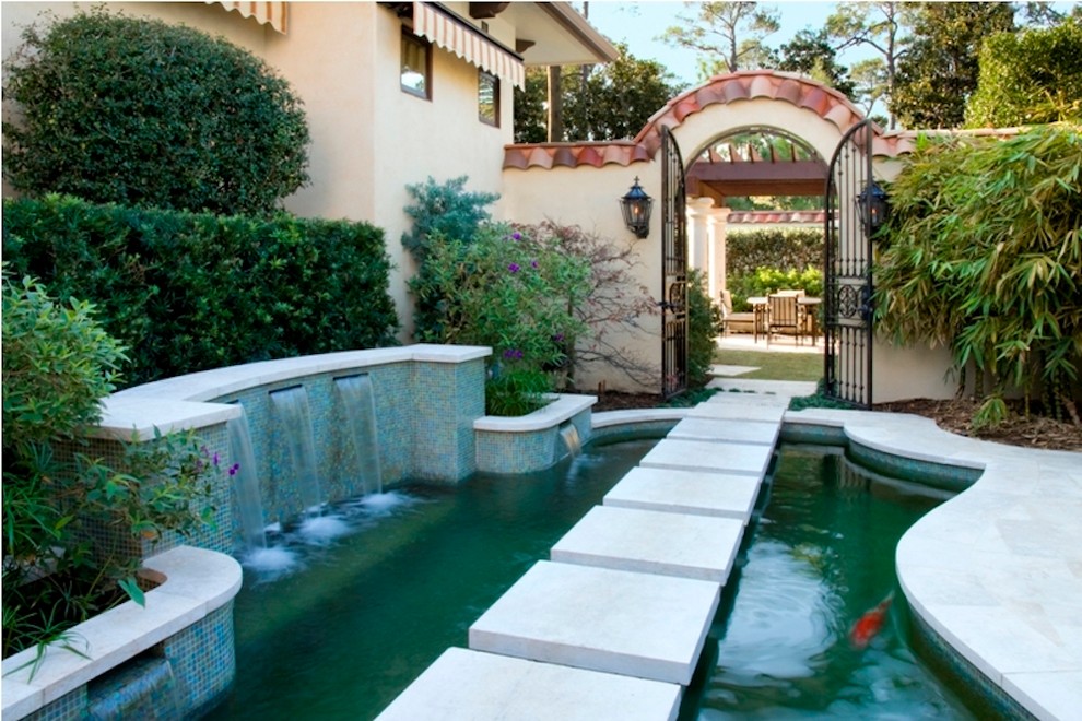 This is an example of a large contemporary side full sun garden in Houston with a water feature and concrete paving.