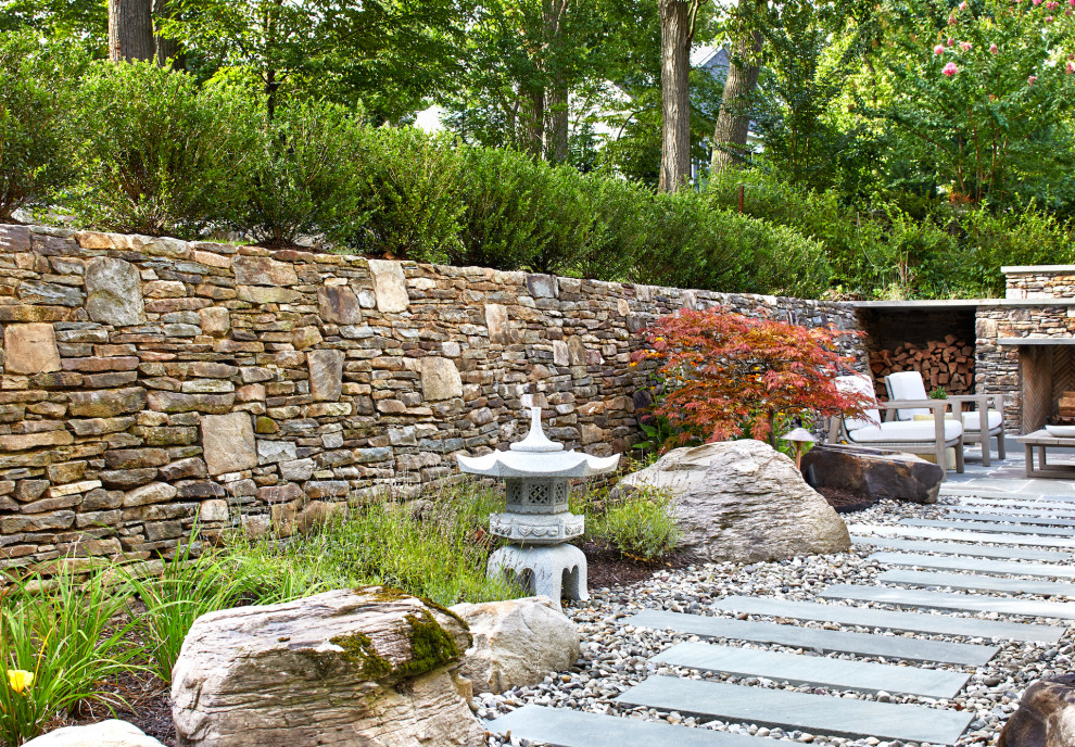 This is an example of a large contemporary full sun backyard stone retaining wall landscape in DC Metro for summer.