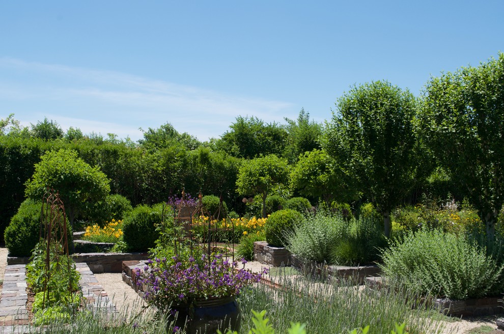 Photo of a large coastal back formal full sun garden for summer in New York with a potted garden and gravel.