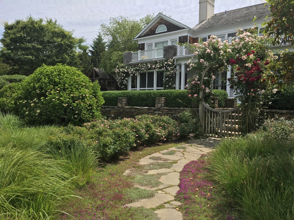 Immagine di un grande giardino formale stile marino esposto in pieno sole davanti casa in primavera con un ingresso o sentiero e pavimentazioni in pietra naturale